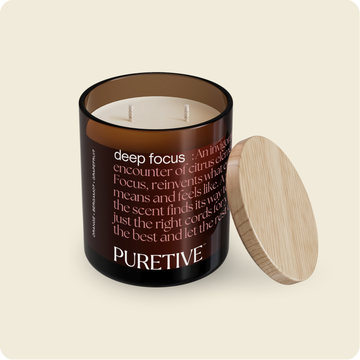 Scented candle with two wicks, dark brown glass container, wooden lid aside, and "PURETIVE" branding.