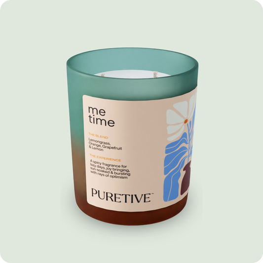 A scented candle labeled 'me time' with notes of lemongrass, orange, grapefruit, and lemon from PURETIVE.